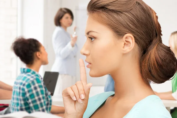 Estudiante haciendo un gesto de silencio en la escuela — Foto de Stock