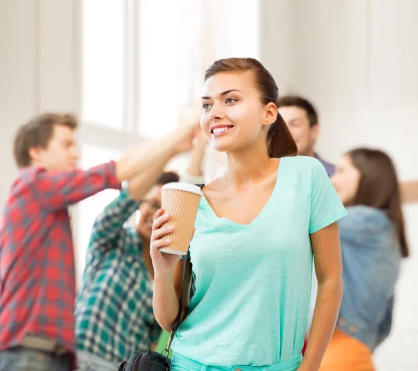 Student holding take away coffee cup in college — Stock Photo, Image