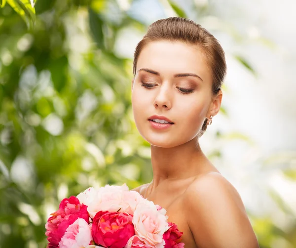 Frau trägt Ohrringe und Blumen — Stockfoto
