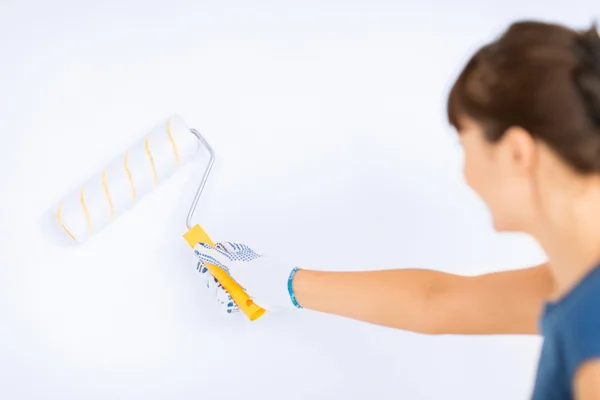 Mulher com rolo e pintura colorir a parede — Fotografia de Stock