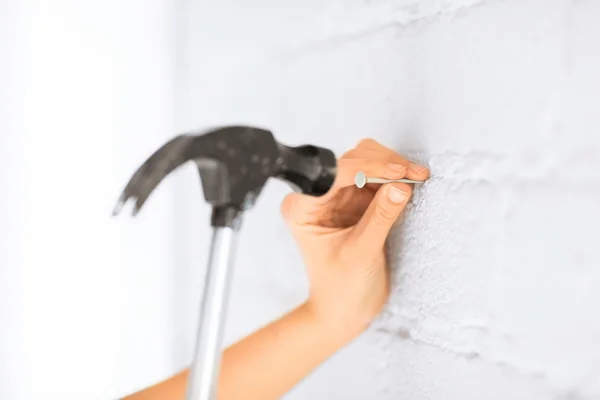 Architect hammering nail in wall — Stock Photo, Image