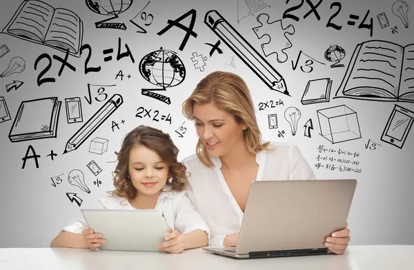 Tjej och mamma med Tablet PC och laptop — Stockfoto