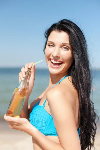 Girl with bottle of drink on the beach — Stock Photo, Image