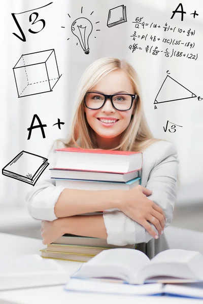 Estudiante con pila de libros y garabatos —  Fotos de Stock