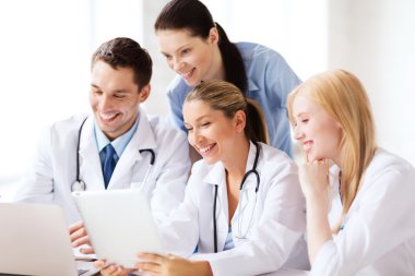 Group of doctors looking at tablet pc clipart