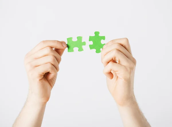 Due mani che cercano di collegare pezzi di puzzle — Foto Stock