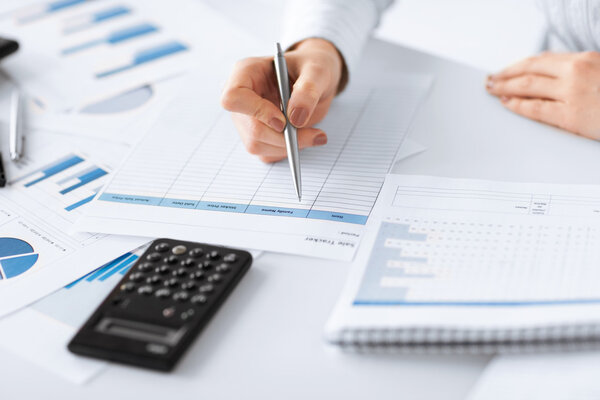 Mujer mano con calculadora y papeles — Foto de Stock