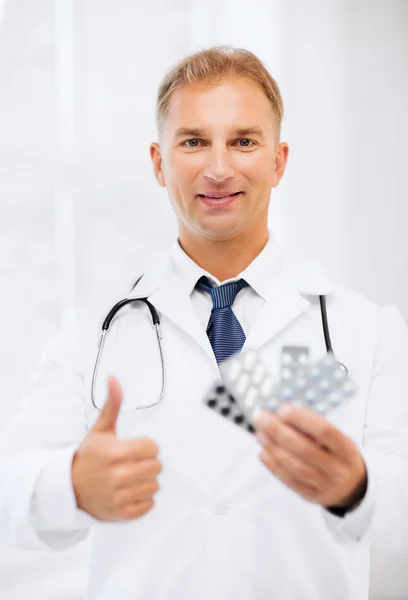 Young male doctor with packs of pills — Stock Photo, Image