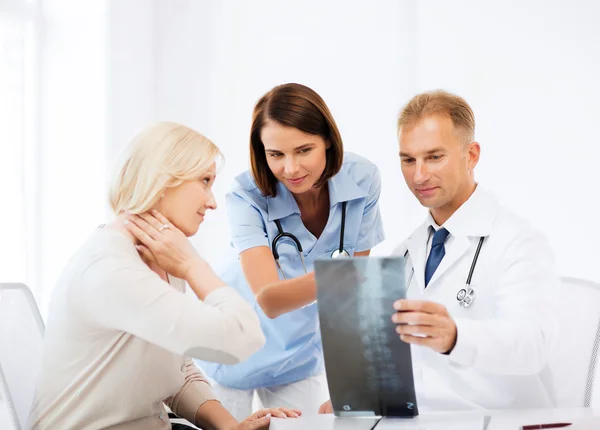 Médicos con paciente mirando rayos X —  Fotos de Stock