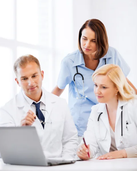 Médicos mirando a la computadora portátil en la reunión — Foto de Stock