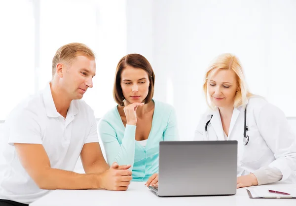 Arzt mit Patienten schaut auf Laptop — Stockfoto