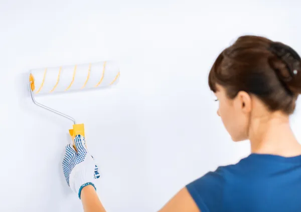 Žena s klecemi a malování, barvení zdi — Stock fotografie