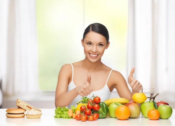 Donna con frutta che rifiuta cibo spazzatura — Foto Stock