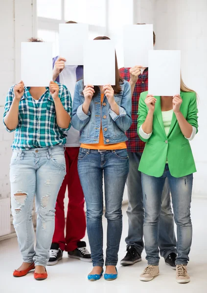 Students covering faces with blank papers
