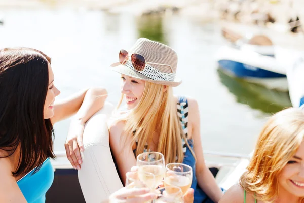 Meisjes met champagneglazen op boot — Stockfoto
