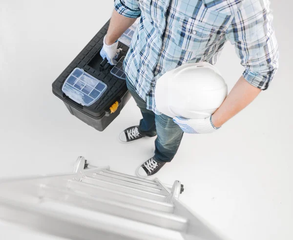 Hombre con escalera, casco y caja de herramientas — Foto de Stock