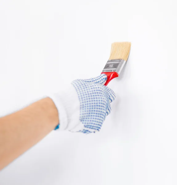 Hand coloring wall with paintbrush — Stock Photo, Image