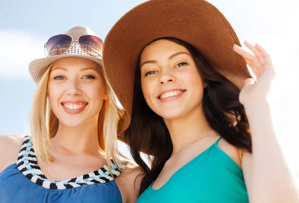 Mädchen mit Hüten am Strand lizenzfreie Stockbilder