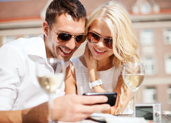 Couple looking at smartphone in cafe — Stock Photo, Image