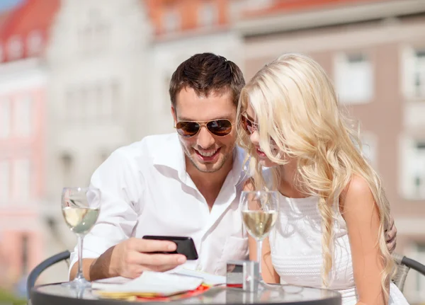 Paar kijken naar smartphone in café — Stockfoto