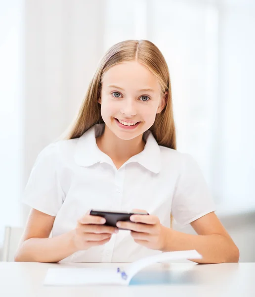 Menina com smartphone na escola — Fotografia de Stock