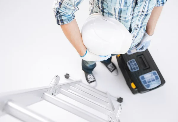 Hombre con escalera, casco y caja de herramientas — Foto de Stock