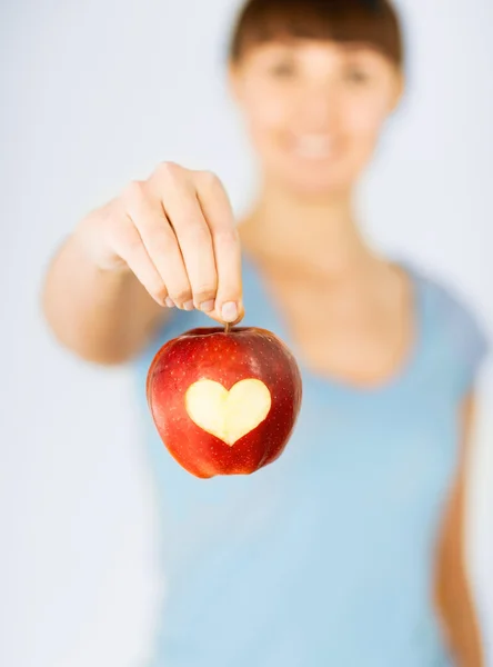 Mujer mano sosteniendo manzana roja con forma de corazón — Foto de Stock