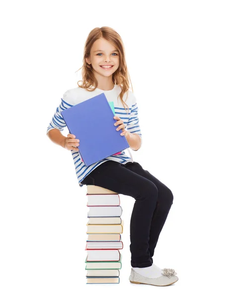 Student meisje zittend op stapel boeken — Stockfoto