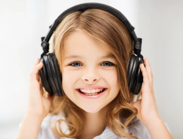 Menina com fones de ouvido em casa — Fotografia de Stock