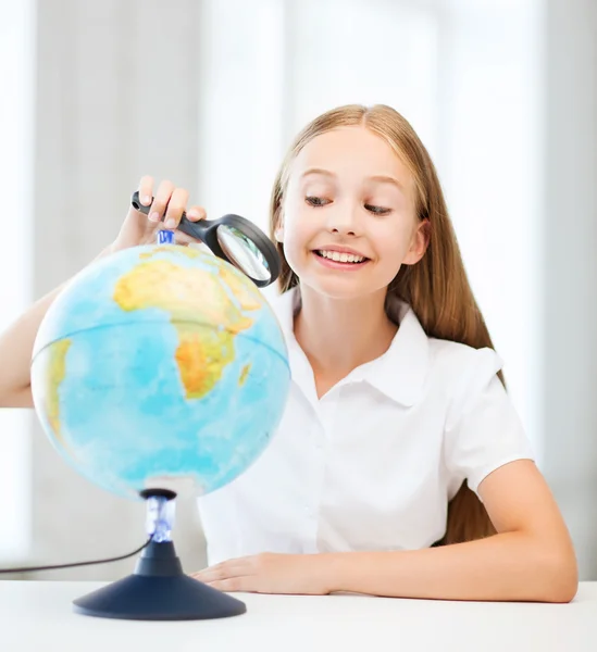 Enfant regardant globe avec loupe — Photo