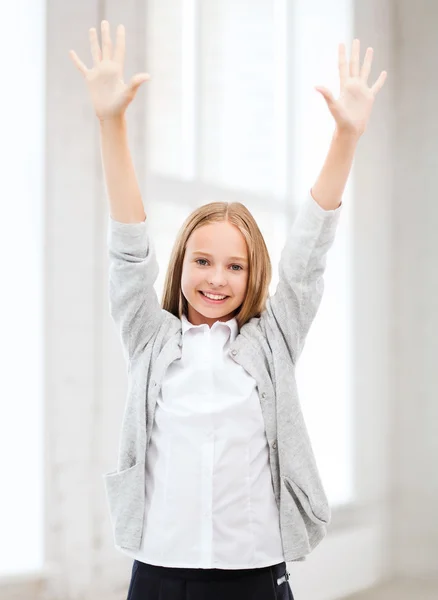 Student meisje met handen omhoog op school — Stockfoto