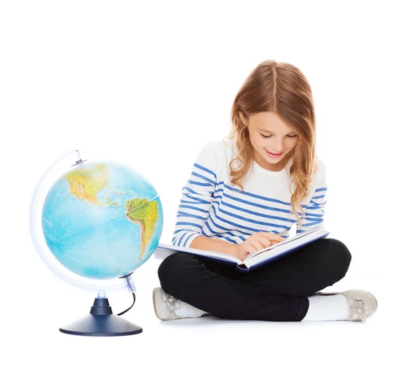 Девочка с глобусом и книгой — стоковое фото