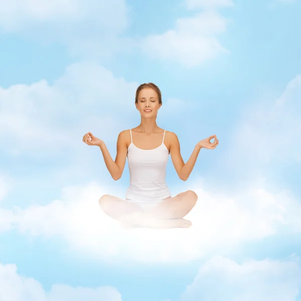 Menina sentada na posição de lótus e meditando — Fotografia de Stock