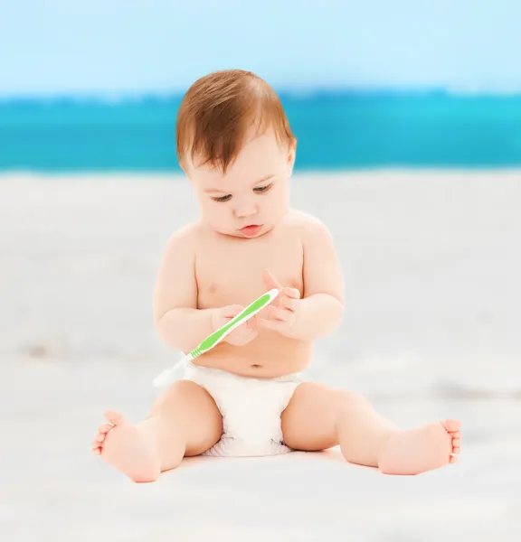 Pequeno bebê brincando com escova de dentes — Fotografia de Stock