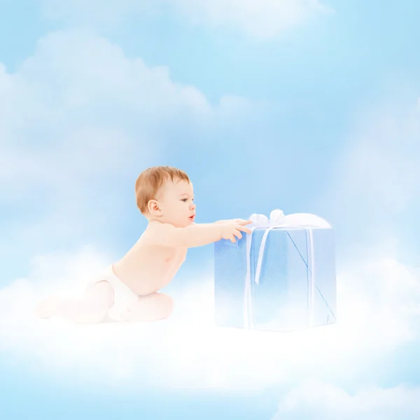 Smiling baby with present on the cloud — Stock Photo, Image