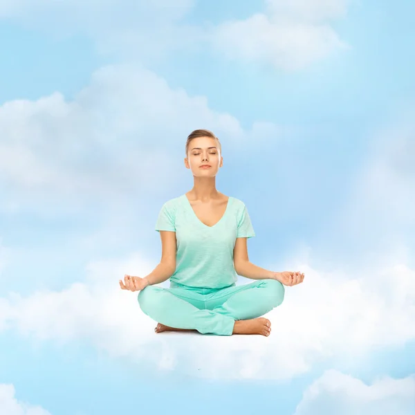 Flickan sitter i lotusställning och mediterar — Stockfoto