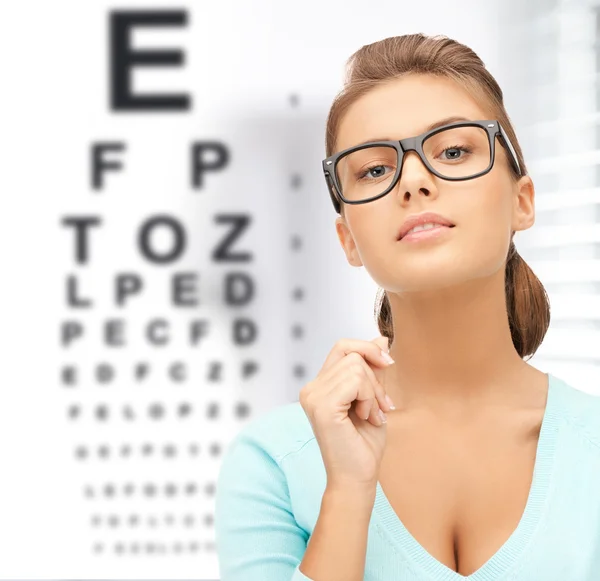 Woman in eyeglasses with eye chart — Stock Photo, Image