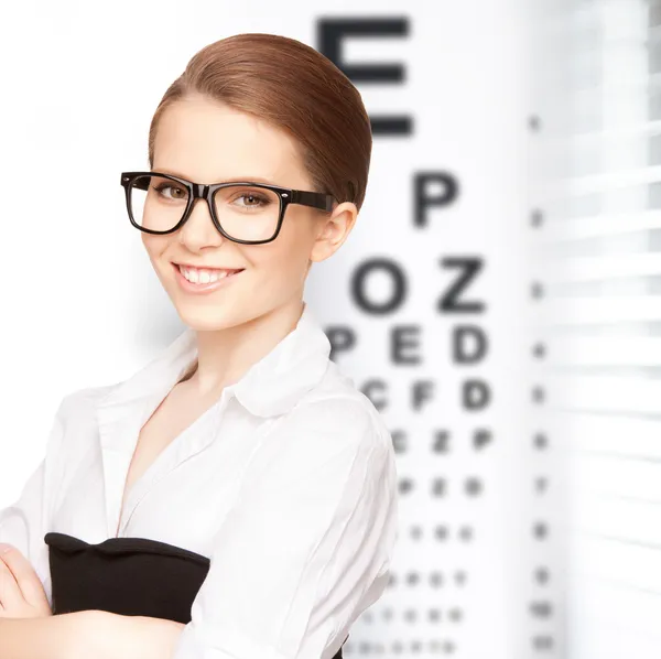 Femme en lunettes avec diagramme de la vue — Photo