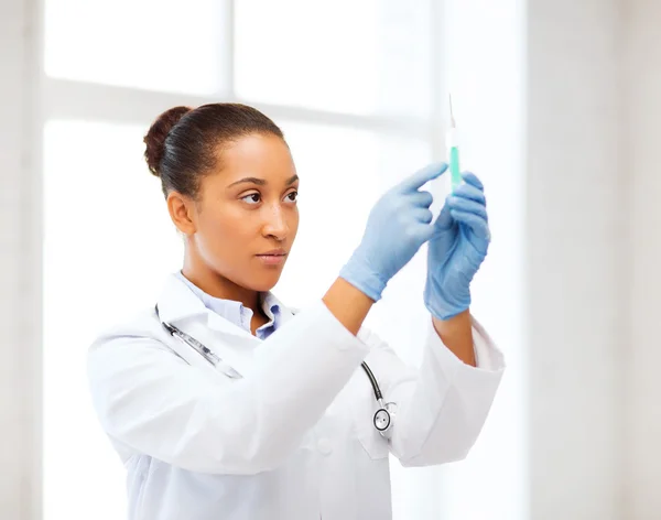 Africano médico segurando seringa com injeção — Fotografia de Stock