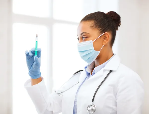 Africano médico segurando seringa com injeção — Fotografia de Stock