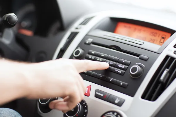 Hombre usando el sistema estéreo audio del coche — Foto de Stock