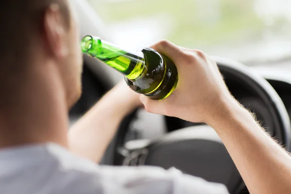 Hombre beber alcohol mientras conduce el coche — Foto de Stock