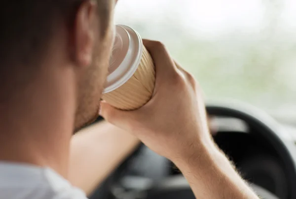 Mann trinkt Kaffee während der Autofahrt — Stockfoto