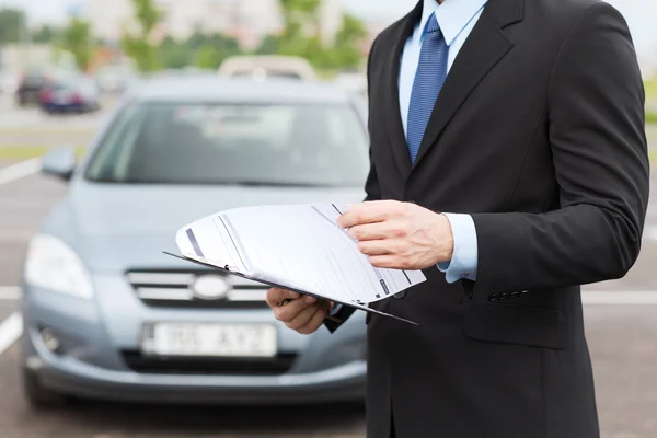 Man with car documents outside — Stock Photo, Image