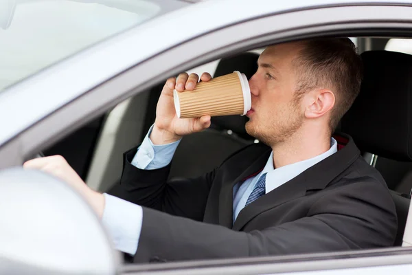 Ο άνθρωπος που πίνει καφέ κατά την οδήγηση το αυτοκίνητο — Φωτογραφία Αρχείου