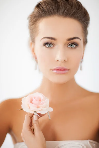 Mladá žena s růžovou květinou — Stock fotografie