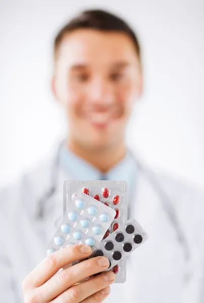 Homme médecin avec des paquets de pilules — Photo