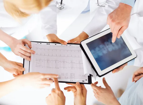 Skupina lékařů při pohledu na x-ray na počítači tablet pc — Stock fotografie