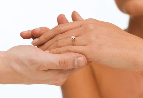 Мужчина надевает обручальное кольцо на руку женщине — стоковое фото