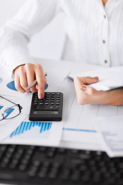 Woman hand with calculator and papers — Stock Photo, Image